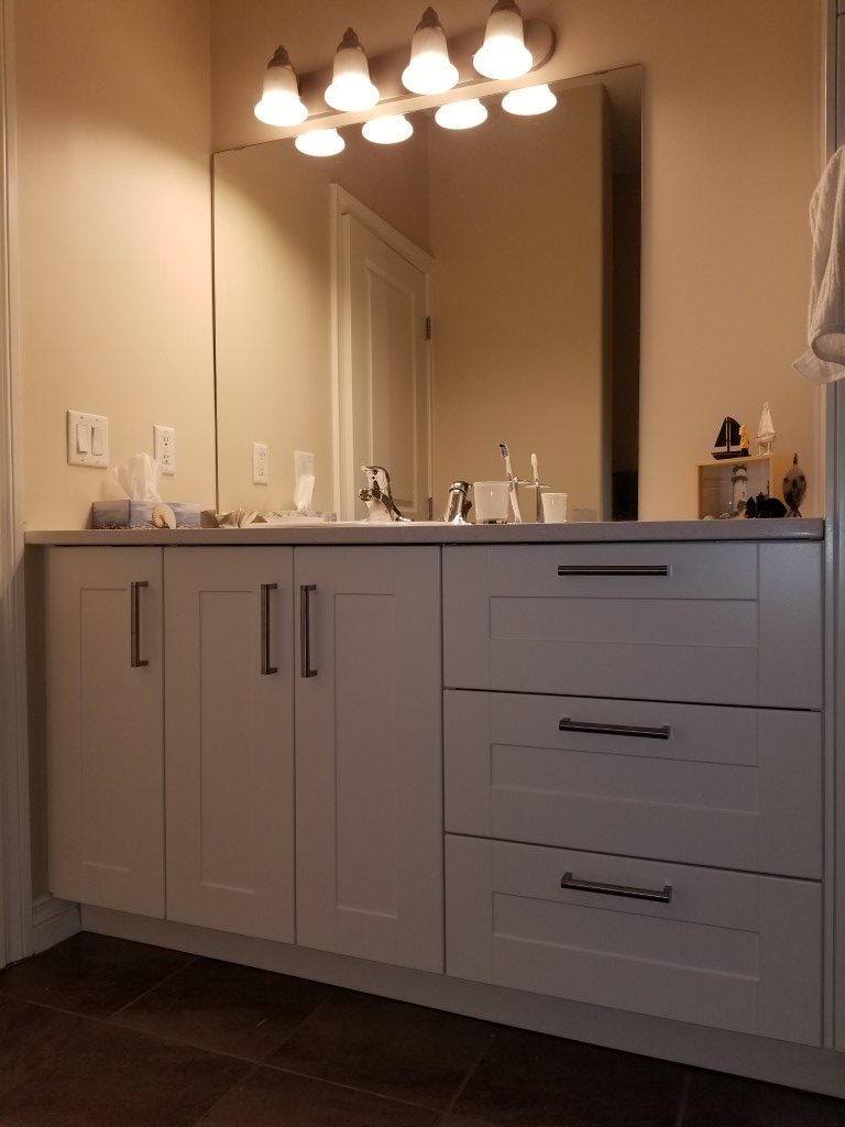 white bathroom cabinets with large mirror above